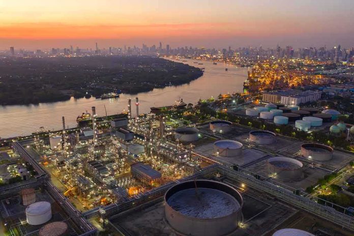 shutterstock_1599038092-1 Industrial oil refinery complex beside a river at dusk