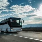 Royal Jordanian Crew Bus Disaster Leaves 2 Dead, 20 Injured White coach bus driving on a highway under a bright sky