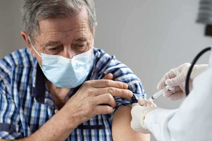 Older man in mask receiving a vaccine injection