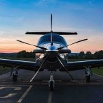 Single-engine propeller airplane on runway at sunset