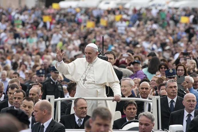 shutterstock_225437089 Francis waves from a vehicle amid a large crowd; Keith Allen and Andreas Hestler are also present