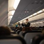 Flight attendant demonstrates safety procedures in airplane cabin