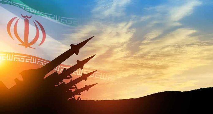shutterstock_2377780377-1 missile silhouettes under Iran flag at sunset