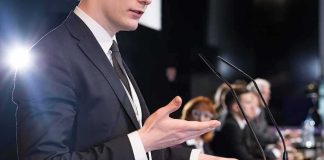 Minaj Brings Spotlight to Entrepreneurship Speaker in suit at podium gesturing during conference