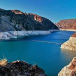 Reservoir between rugged desert cliffs with stark white shoreline