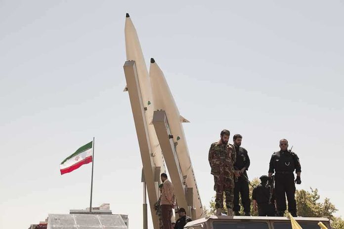 shutterstock_681421708-1 Soldiers stand beside large missiles at an outdoor display