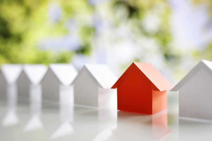 shutterstock_730204513 Red paper house among white paper houses
