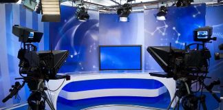 Fox News Exit Sparks Dispute Over Anchor’s Employment Status A television studio setup with cameras and a blue backdrop