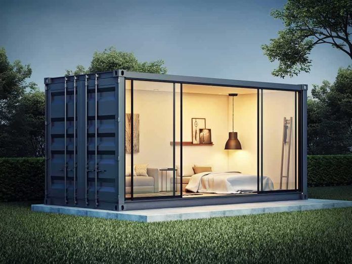 shutterstock_1055227163 shipping container home with glass walls at dusk