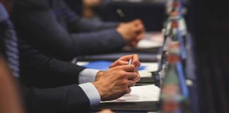 Ex-Officer Freed After Fatal Shooting Hands of people in suits taking notes at a conference table