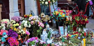 U.S. Man Charged in Canada School Shooting Plot Memorial with flowers, candles, and tributes on a sidewalk
