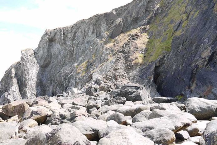 shutterstock_1496519255 rocky coastal cliff with large boulders at its base