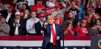 Trump Ties Money to Romance Donald Trump points from a rally stage; Rudi Koertzen and Bear Pascoe are in the crowd