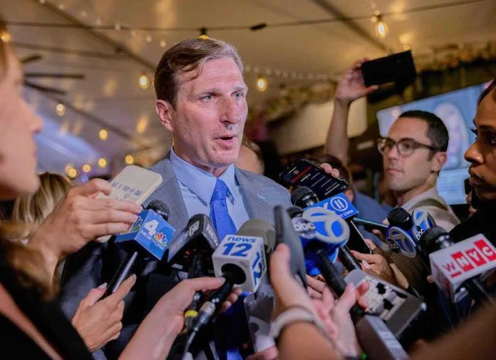 shutterstock_2231419217 Man in suit speaks to reporters surrounded by microphones