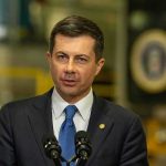 Pete Buttigieg speaking at a podium with microphones