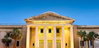 Supreme Court building with illuminated columns at dusk