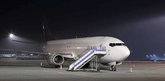 Co-Pilot Attack Forces Emergency Flight Diversion Passenger airplane parked on tarmac at night with mobile stairs