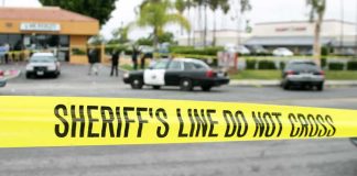 Haunted House Assault Scandal yellow sheriff's line tape blocks a street near police cars